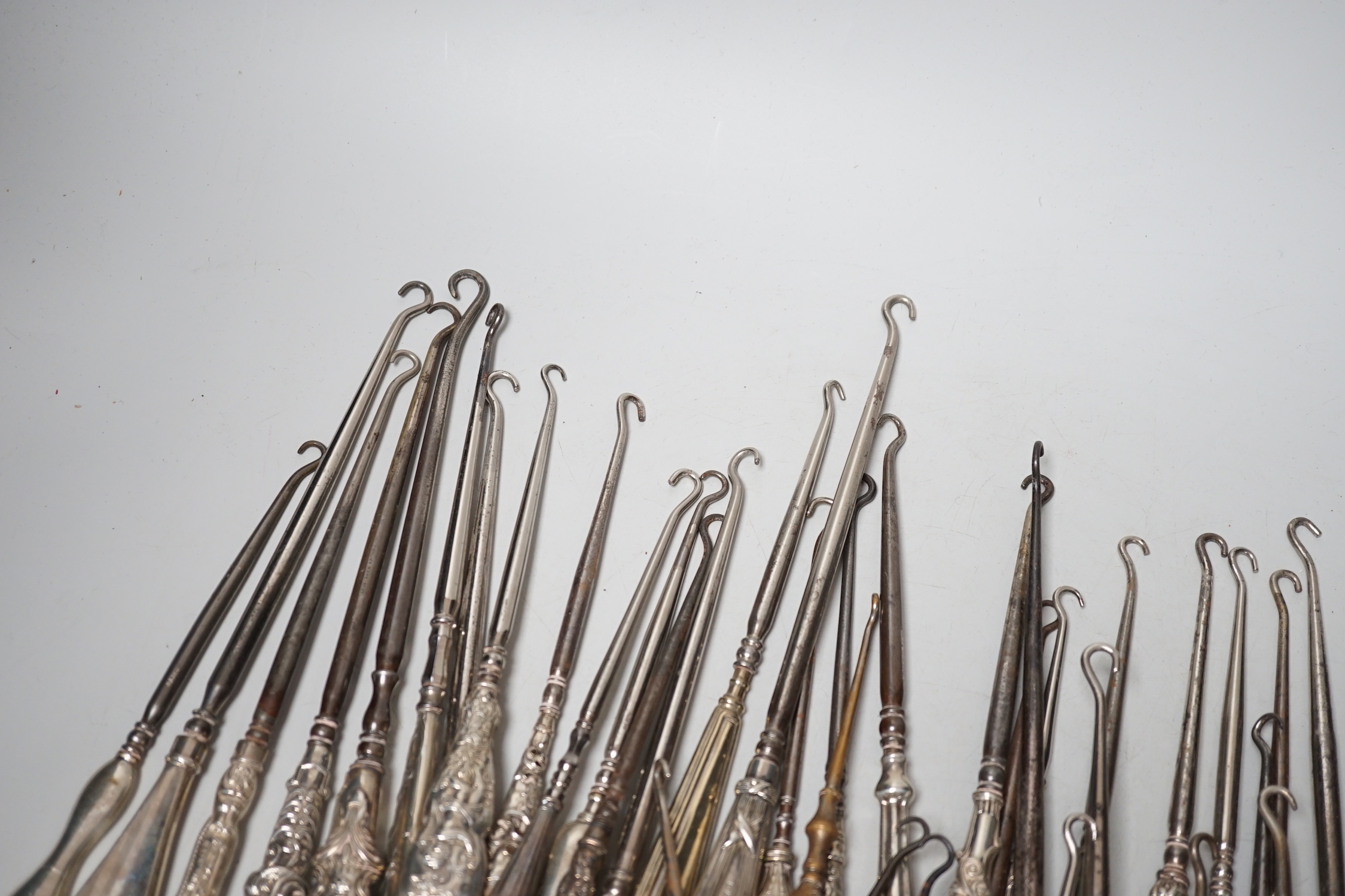 A large collection of mainly silver handled button hooks and two shoe horns.